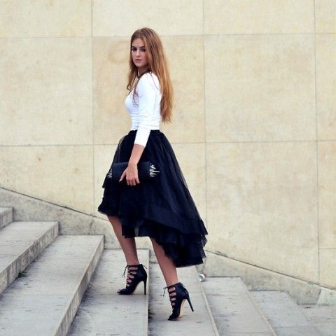 Pretty girl wearing a black high-low skirt and a plain white top.
