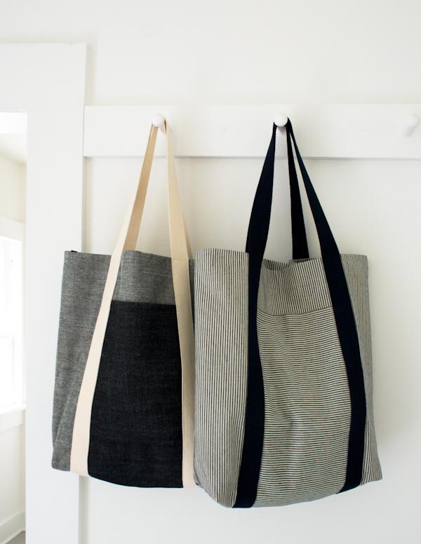 two tote bags hanging on hooks